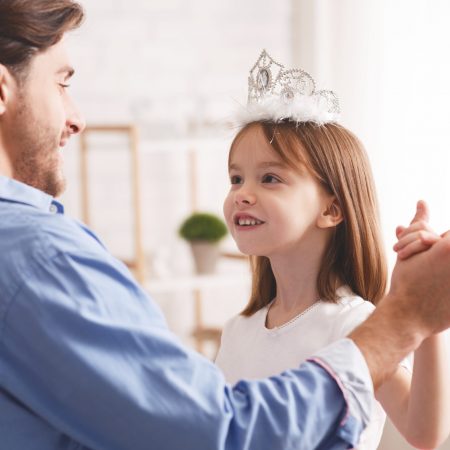 Close up of handsome dad dancing with his daughter indoor, happy to be father